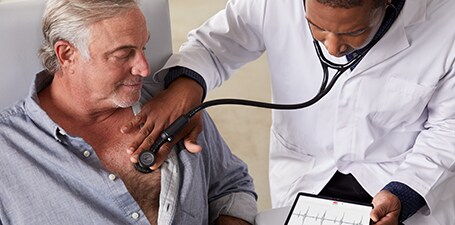 Clinician holding 3M Littmann CORE Digital Stethoscope to man’s chest
